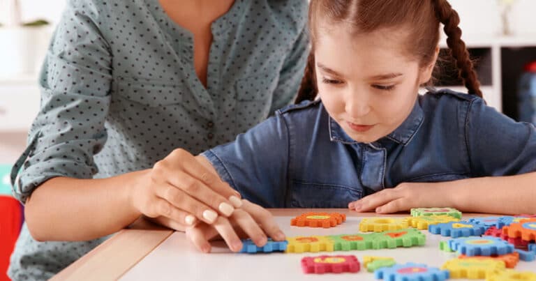 Mother with autistic daughter doing tactile play