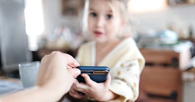 Mother retrieving phone from daughter